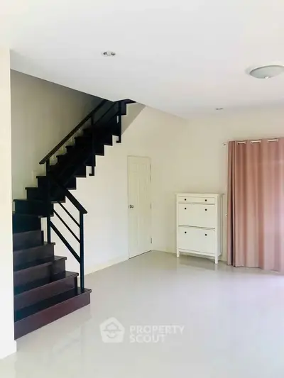 Modern interior with sleek staircase and minimalist decor in bright living space.