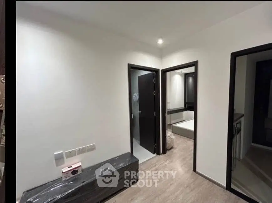 Modern interior with sleek design, featuring a hallway leading to a bedroom and bathroom.