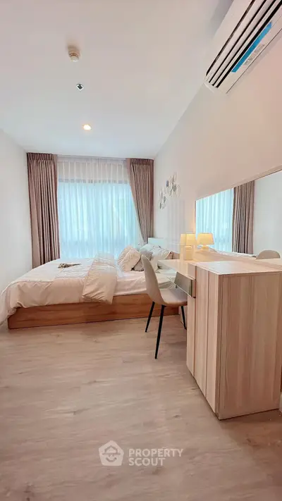 Cozy bedroom with modern decor and natural light, featuring a stylish desk and comfortable bed.