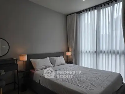 Modern bedroom with large windows and elegant decor in a stylish apartment.