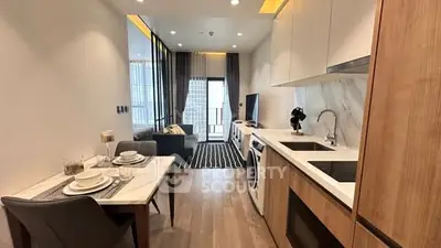 Modern open-layout kitchen and living area with stylish decor and balcony access.
