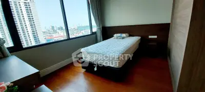 Modern bedroom with city view, featuring a single bed and wooden flooring.