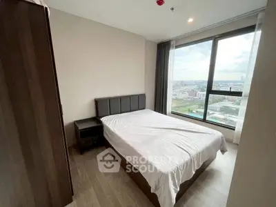 Modern bedroom with large window offering stunning city view