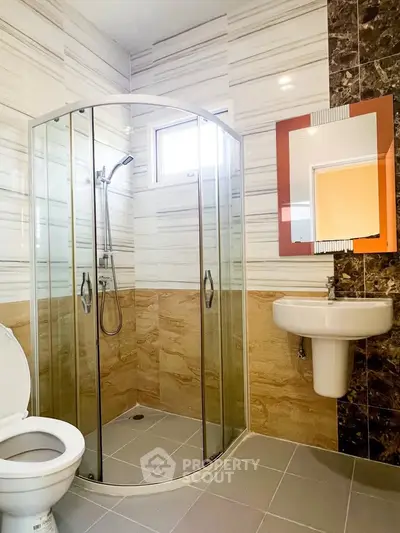 Modern bathroom with glass shower enclosure and stylish tile design