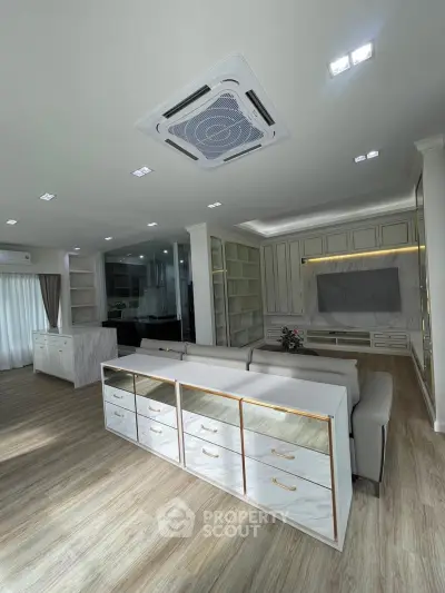 Spacious modern living room with elegant built-in shelves and stylish ceiling air conditioning.