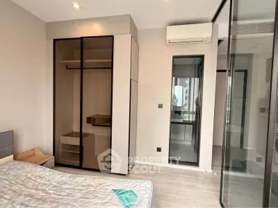 Modern bedroom with sleek wardrobe and large window in a stylish apartment.