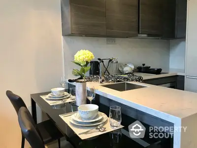 Modern kitchen with sleek cabinetry and a stylish breakfast bar set for two, featuring elegant tableware and a vibrant floral centerpiece.