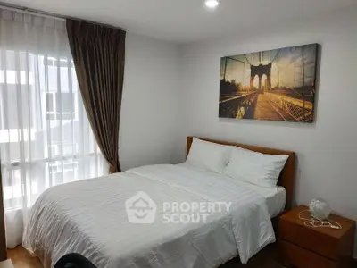 Cozy bedroom with large window and stylish decor in modern apartment