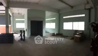 Spacious industrial interior with large windows and high ceilings