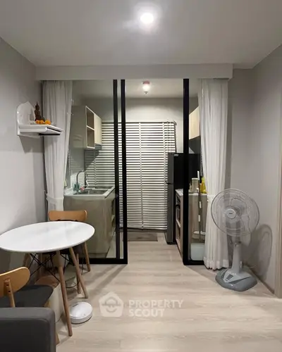 Modern compact kitchen with open layout and dining area, featuring sleek appliances and minimalist design.