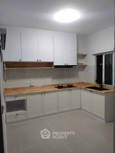 Modern kitchen with sleek white cabinets and gas stove