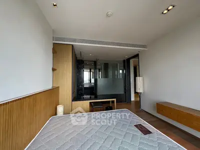 Spacious modern bedroom with wooden accents and large windows offering natural light.
