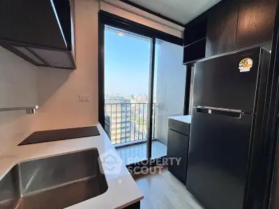 Modern kitchen with sleek appliances and balcony view in urban apartment