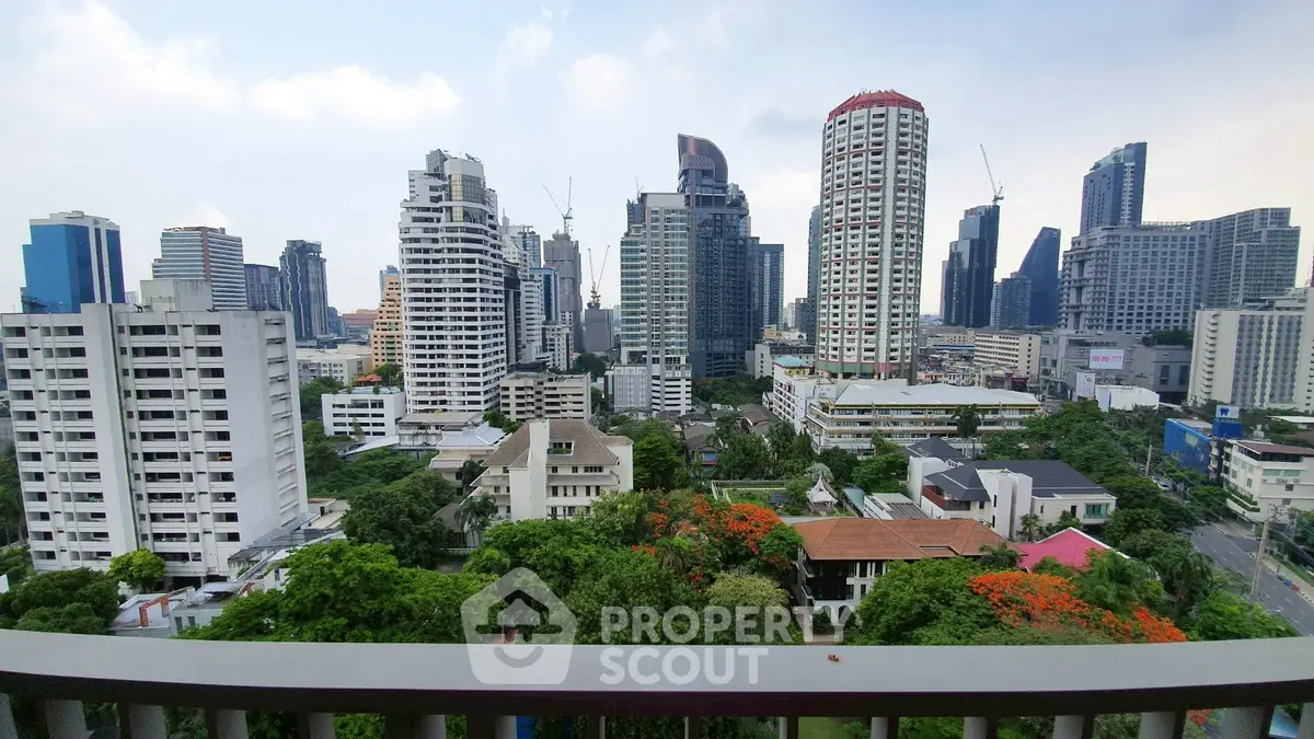 Stunning cityscape view from a high-rise balcony overlooking modern skyscrapers and lush greenery.