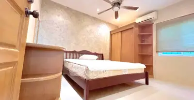 Cozy bedroom with wooden furniture, ceiling fan, and air conditioning in a serene setting.