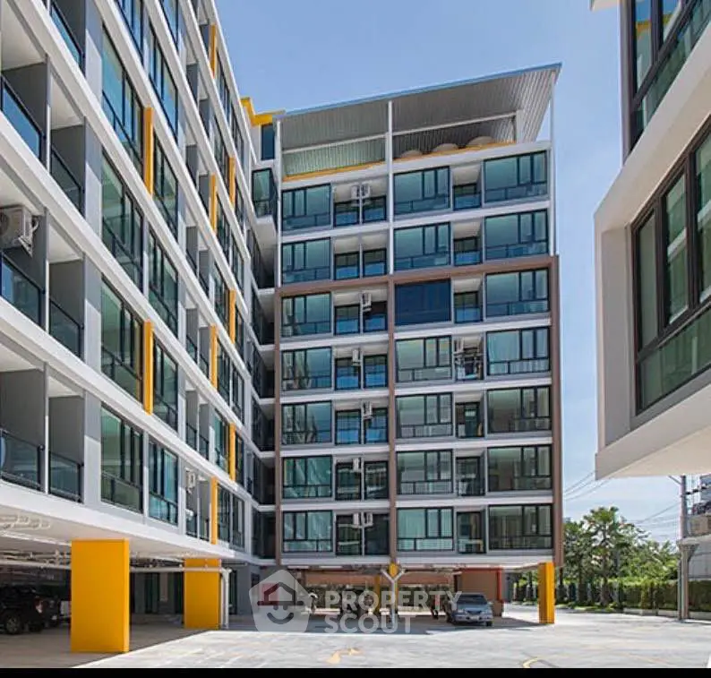 Modern apartment building with large windows and vibrant yellow accents