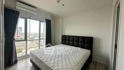 Modern bedroom with large windows offering city views, featuring a comfortable bed and sleek design.