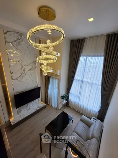 Luxurious living room with high ceilings, elegant chandelier, and modern decor in a stylish apartment.