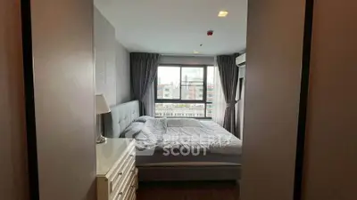 Cozy bedroom with large window and modern furnishings in urban apartment