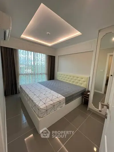 Modern bedroom with stylish ceiling lights and large window in a contemporary apartment.