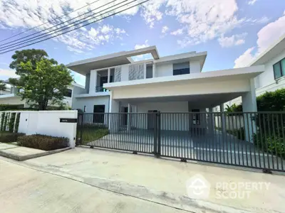 Modern two-story house with sleek design and spacious driveway in a serene neighborhood.