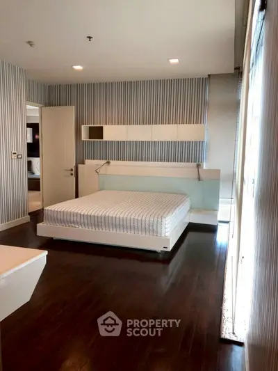 Spacious modern bedroom with sleek design and hardwood floors