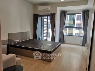 Spacious bedroom with modern design, large windows, and balcony access, featuring elegant drapery and ample natural light.
