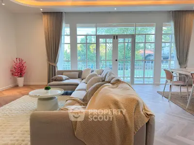 Spacious living room with elegant decor and large windows offering a serene view.