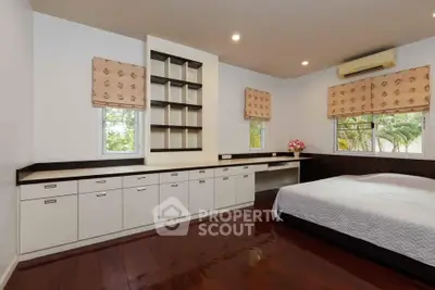 Spacious bedroom with built-in storage and large windows