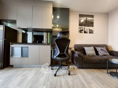 Modern living room with sleek kitchen, stylish sofa, and ergonomic chair for a comfortable lifestyle.