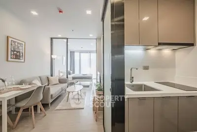 Modern open-plan living room and kitchen with stylish decor and natural light.