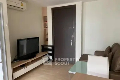 Modern living room with sleek furniture and entertainment center, featuring a flat-screen TV and air conditioning.