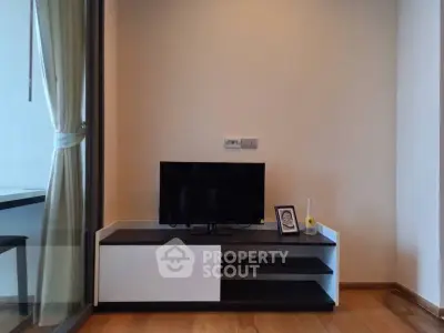 Modern living room with sleek TV stand and glass balcony door, perfect for urban living.