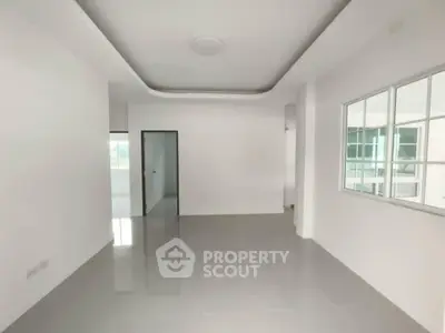 Spacious modern living room with sleek white walls and large windows for natural light.