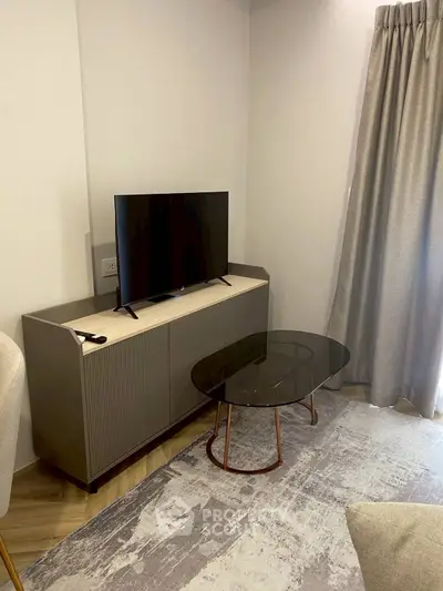 Modern living room corner with sleek TV stand and glass coffee table