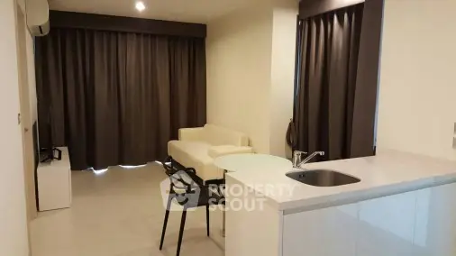 Modern open-plan living room with sleek kitchen and cozy seating area.