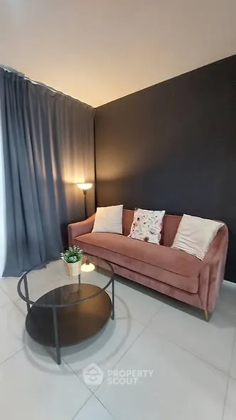 Chic living room with stylish pink sofa and modern round glass coffee table.