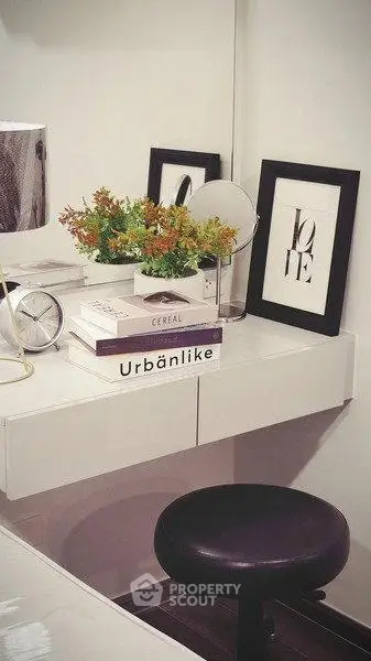 Stylish modern study nook with sleek white desk, decorative books, and chic decor accents.