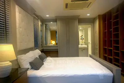 Cozy bedroom with elegant decor and ensuite bathroom, featuring built-in wardrobe and soft lighting.