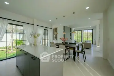 Spacious open-plan kitchen and dining area with garden view, modern design and ample natural light.