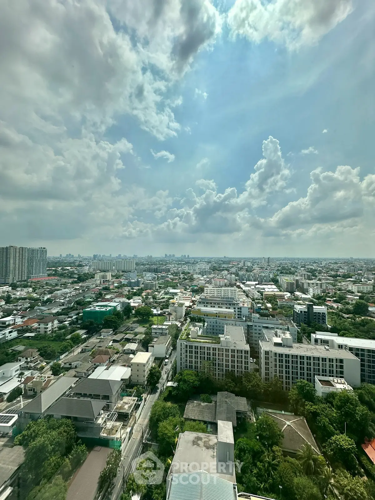 Stunning cityscape view from high-rise building showcasing urban skyline and lush greenery.