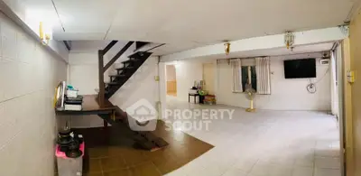 Spacious open-plan living area with staircase and tiled flooring, ideal for modern living.