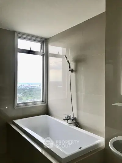 Modern bathroom with bathtub and scenic window view in high-rise apartment.
