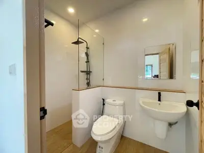 Modern bathroom with sleek fixtures and glass shower enclosure in a stylish home.