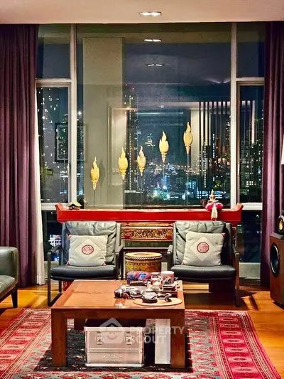 Luxurious living room with city view, elegant decor, and cozy seating area.