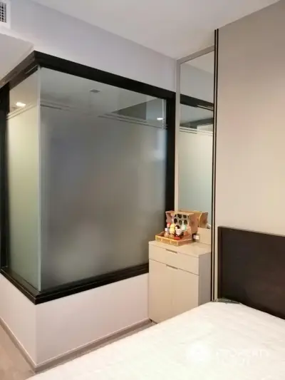 Modern bedroom with frosted glass partition and sleek design