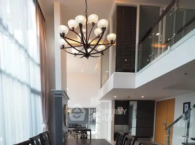Luxurious modern living room with high ceilings and elegant chandelier in a stylish apartment.
