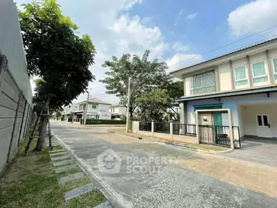 Charming suburban house with spacious driveway and lush greenery in a peaceful neighborhood.