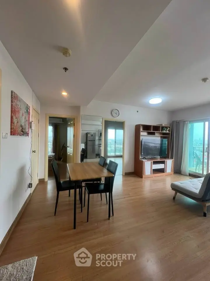 Spacious living room with modern dining area and large windows offering natural light.