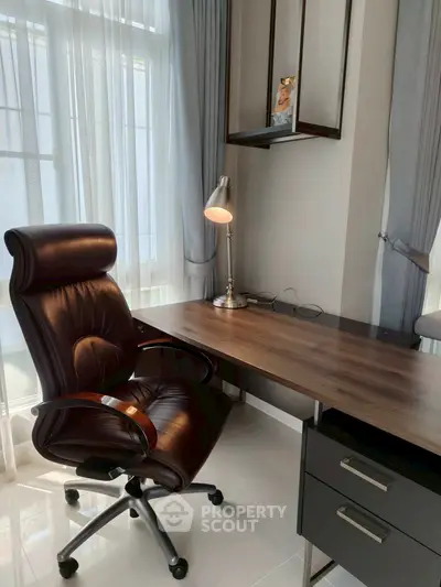 Modern home office with sleek desk and leather chair, perfect for productivity.
